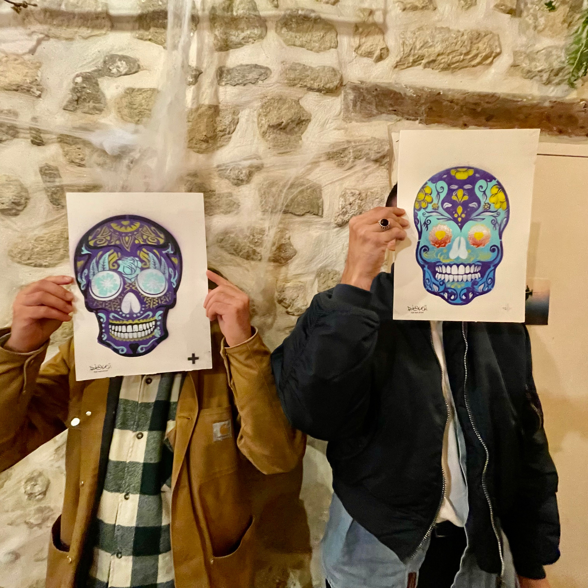 Deux participants tiennent leurs calaveras réalisées au pochoir
